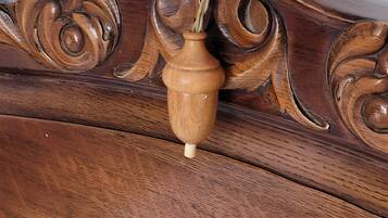 A wooden headboard with intricate carvings and a vase.