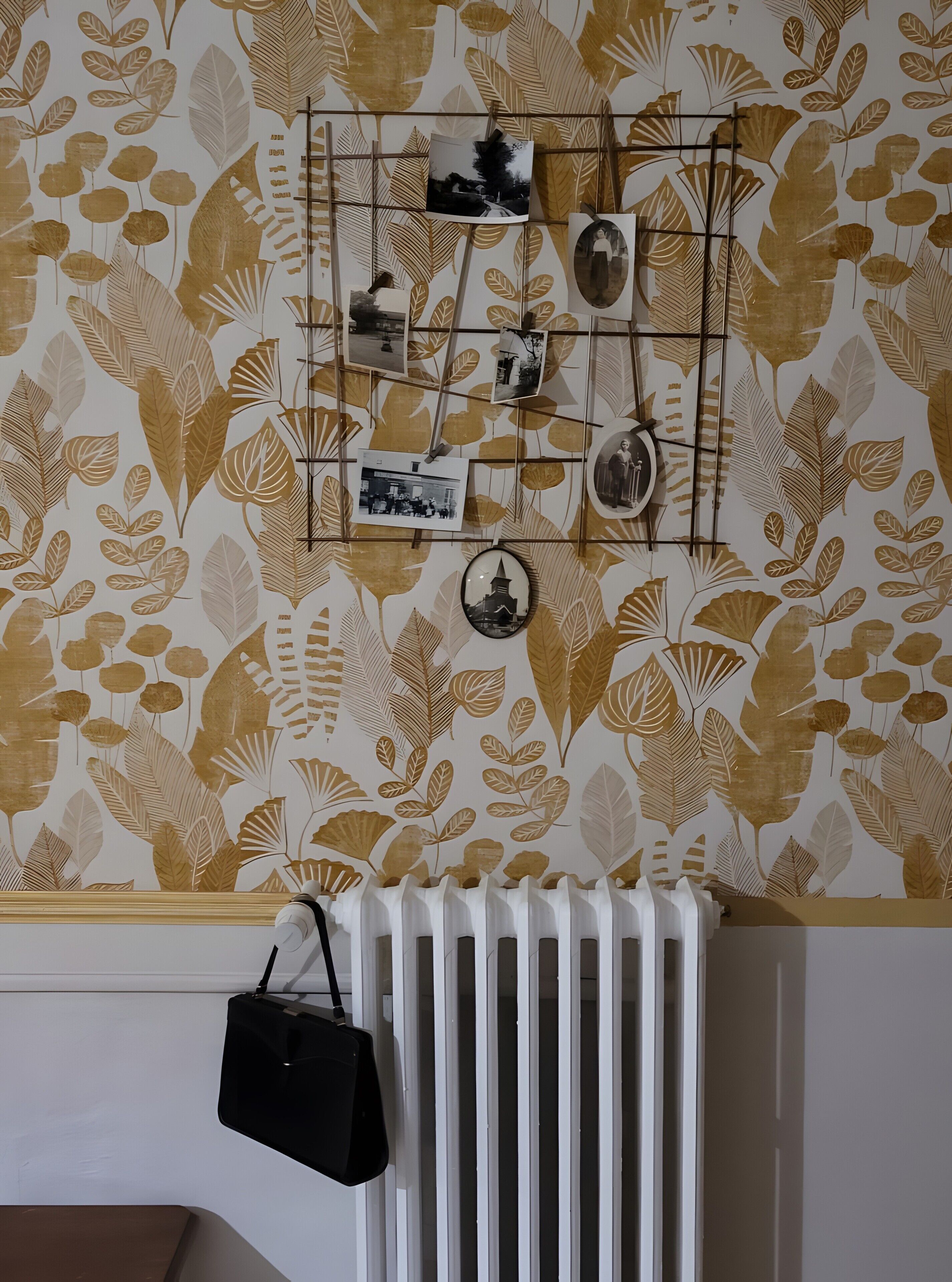 A wall with a leaf pattern and a photo display.