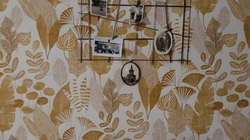 A wall with a leaf pattern and a photo display.