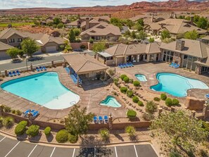 A resort with multiple swimming pools, lounge areas, and a desert landscape in the background. - Cactus Rose at Coral Ridge | Sage Vacations (Washington)