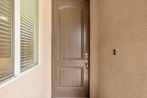 A brown door with a keyhole and a doorbell. - Cactus Rose at Coral Ridge | Sage Vacations (Washington)