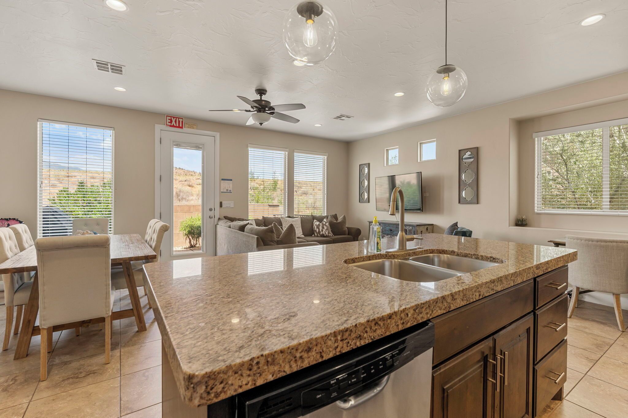 A modern kitchen with granite countertops, a dishwasher, and a built-in oven.