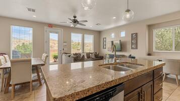 A modern kitchen with granite countertops, a dishwasher, and a built-in oven.