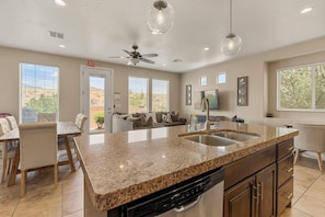 A modern kitchen with granite countertops, a dishwasher, and a built-in oven. - Cactus Rose at Coral Ridge | Sage Vacations (Washington)