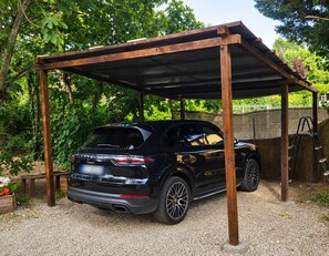 A black SUV parked under a wooden pergola in a garden setting. - ALMA CALMA - 4-bedroom villa with AC in Granarolo Dell'emilia near Bologna Fiera (Granarolo Dell'emilia E Via Dagol)