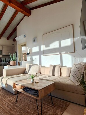 Ein Wohnzimmer mit Sofa, Couchtisch und einem großen Fenster.
