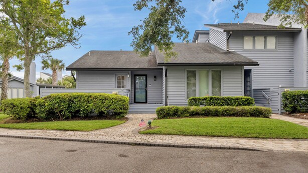 A residential house with a front yard, a mailbox, and a small American flag. - Greenside Getaway - 2BR condo w/ pool access & golf views (Ponte Vedra Beach)