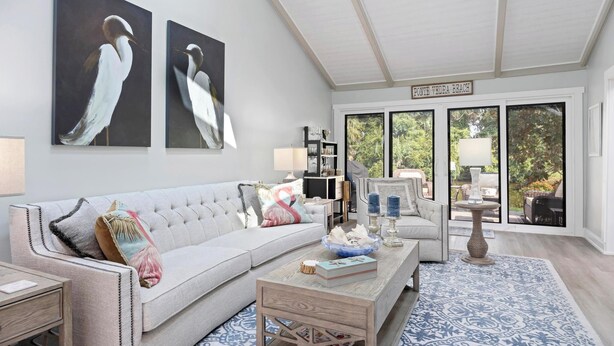 A living room with a sofa, coffee table, and artwork on the wall. - The Sawgrass Sanctuary (PONTE VEDRA BEACH)