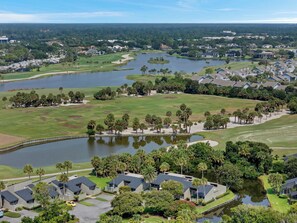 Ein Wohngebiet mit Häusern, einem Golfplatz und einem See.