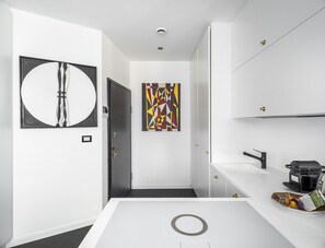 A modern bathroom with a white sink, a coffee machine, and a decorative plate on the counter. - Porta Nuova 52 Design Apartment R&R (Milan)