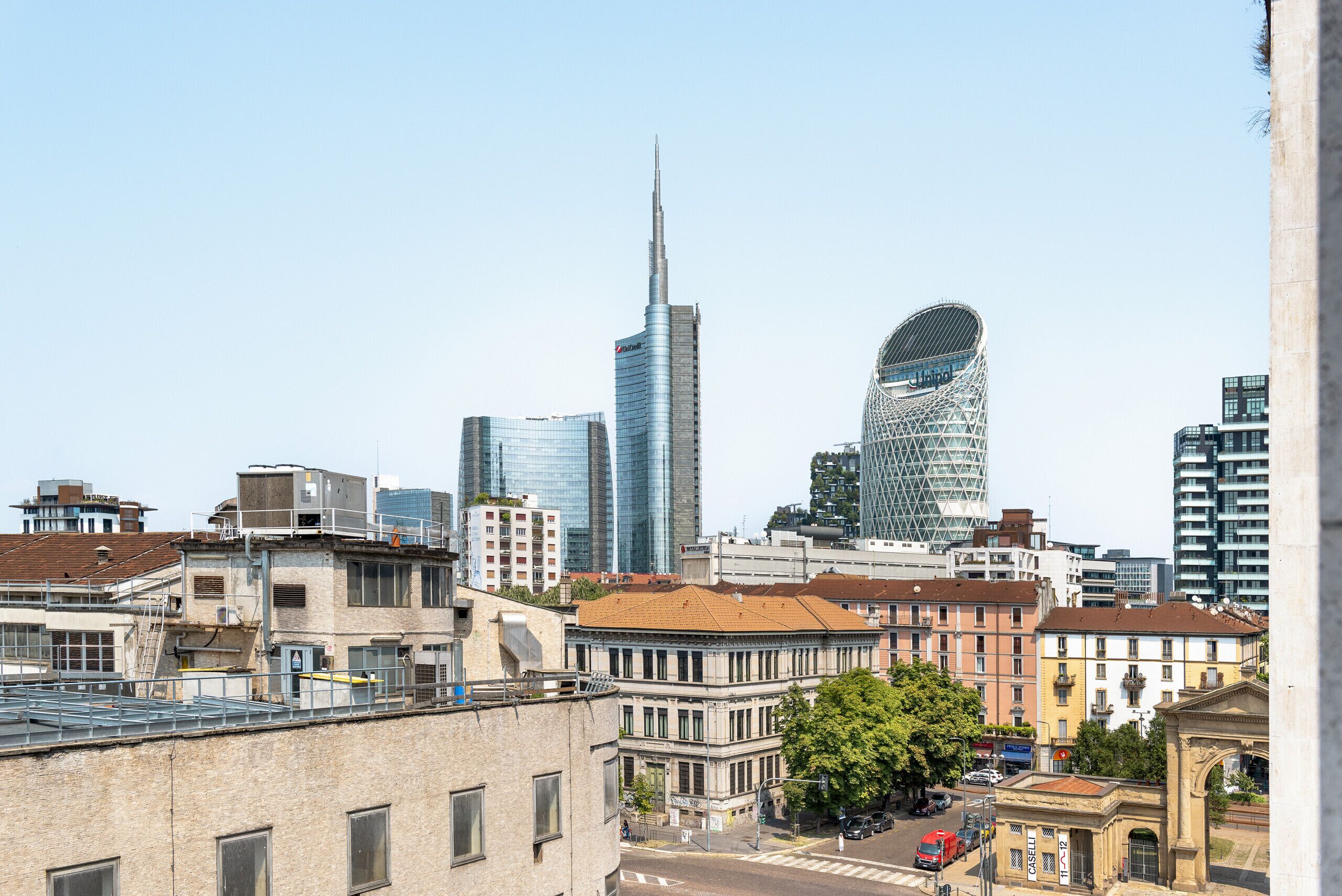 A cityscape with modern skyscrapers, historic buildings, and a clear sky.