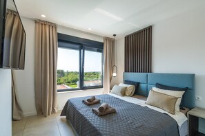A hotel room with a large bed, a view through a window, and a TV mounted on the wall. - Enjoy a relaxing stay at Villa Sea View Saleda, a modern four-bedroom villa for up to nine guests with a private pool, jacuzzi, summer kitchen and panoramic views towards the sea. (Krnica)