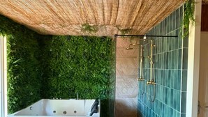 A modern bathroom with a large bathtub, a shower area, and a green wall. - L'Évidence - Love Room & Spa (Chaveignes)
