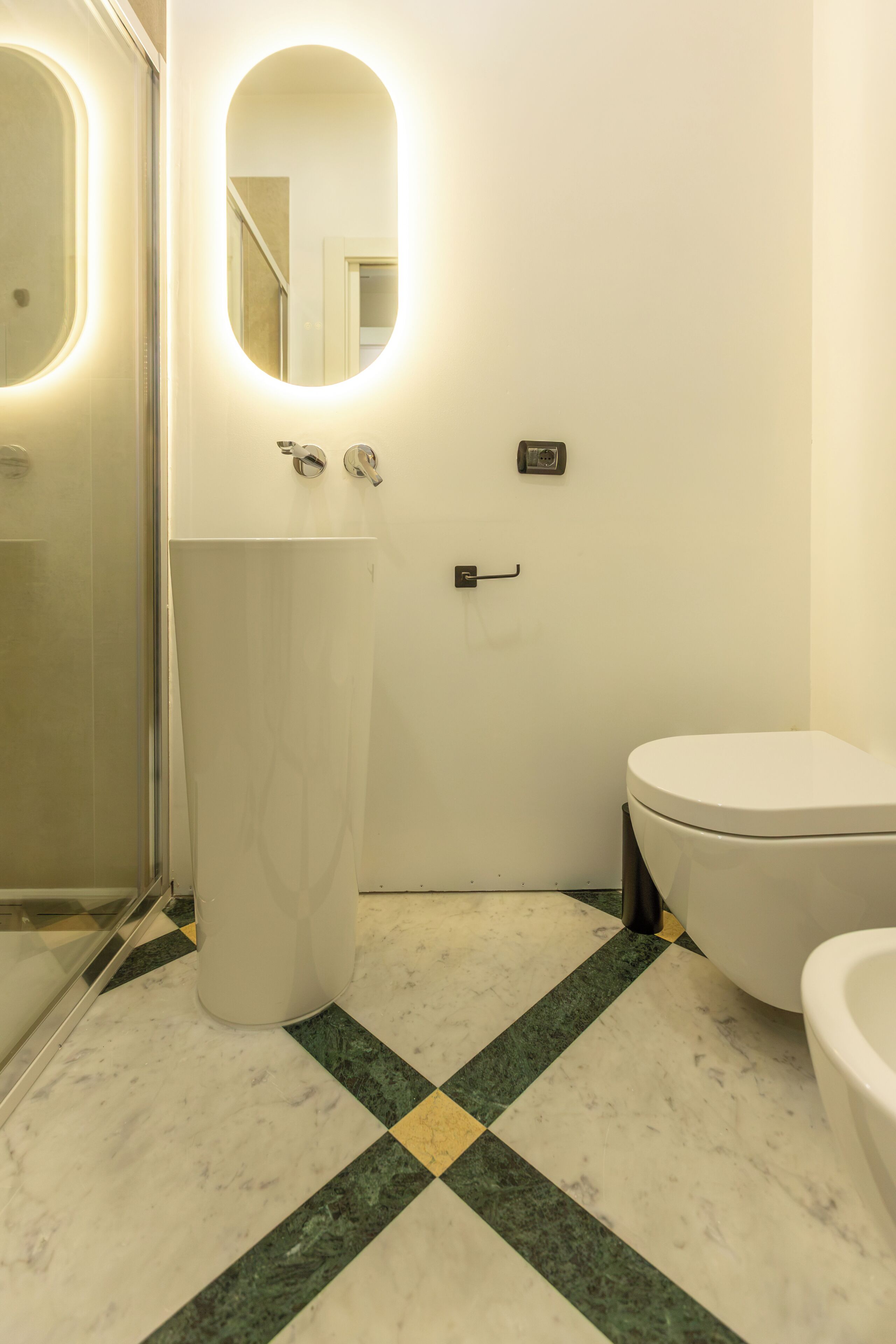 Un baño con inodoro, lavamanos y espejo.