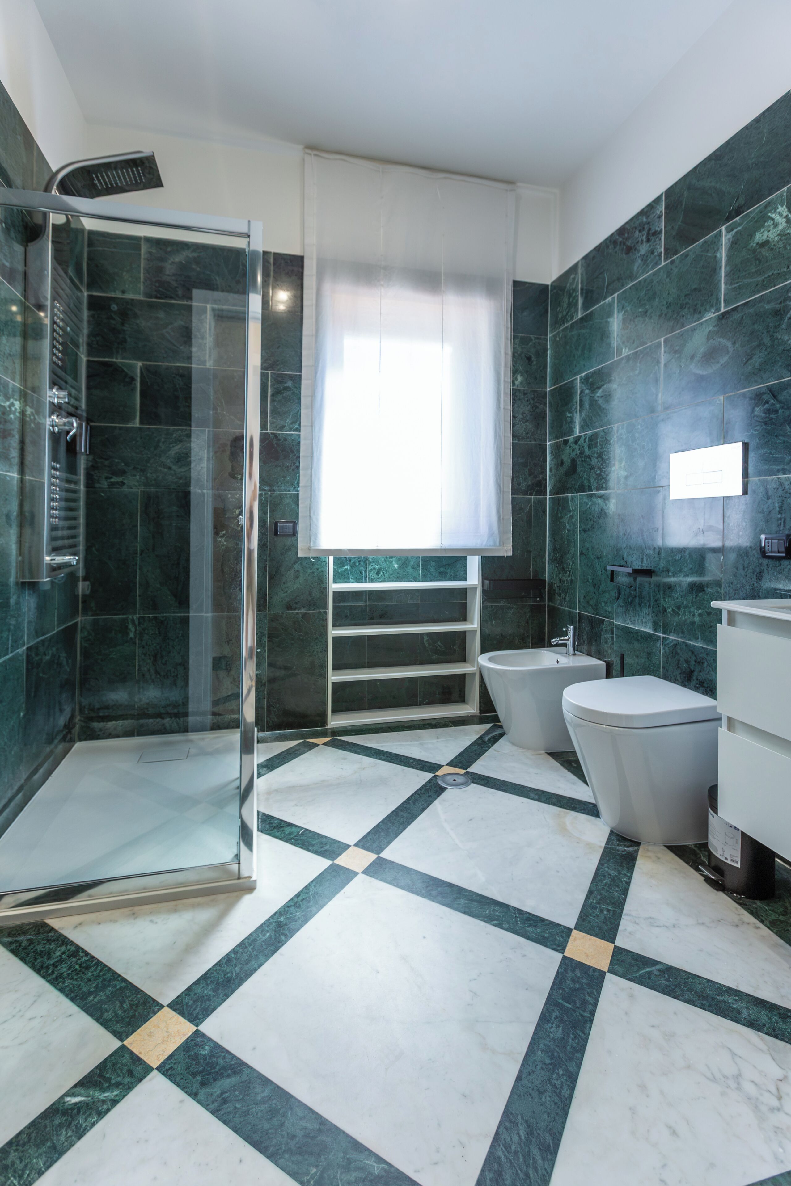 Un baño moderno con cabina de ducha de vidrio, una bañera independiente y un inodoro.