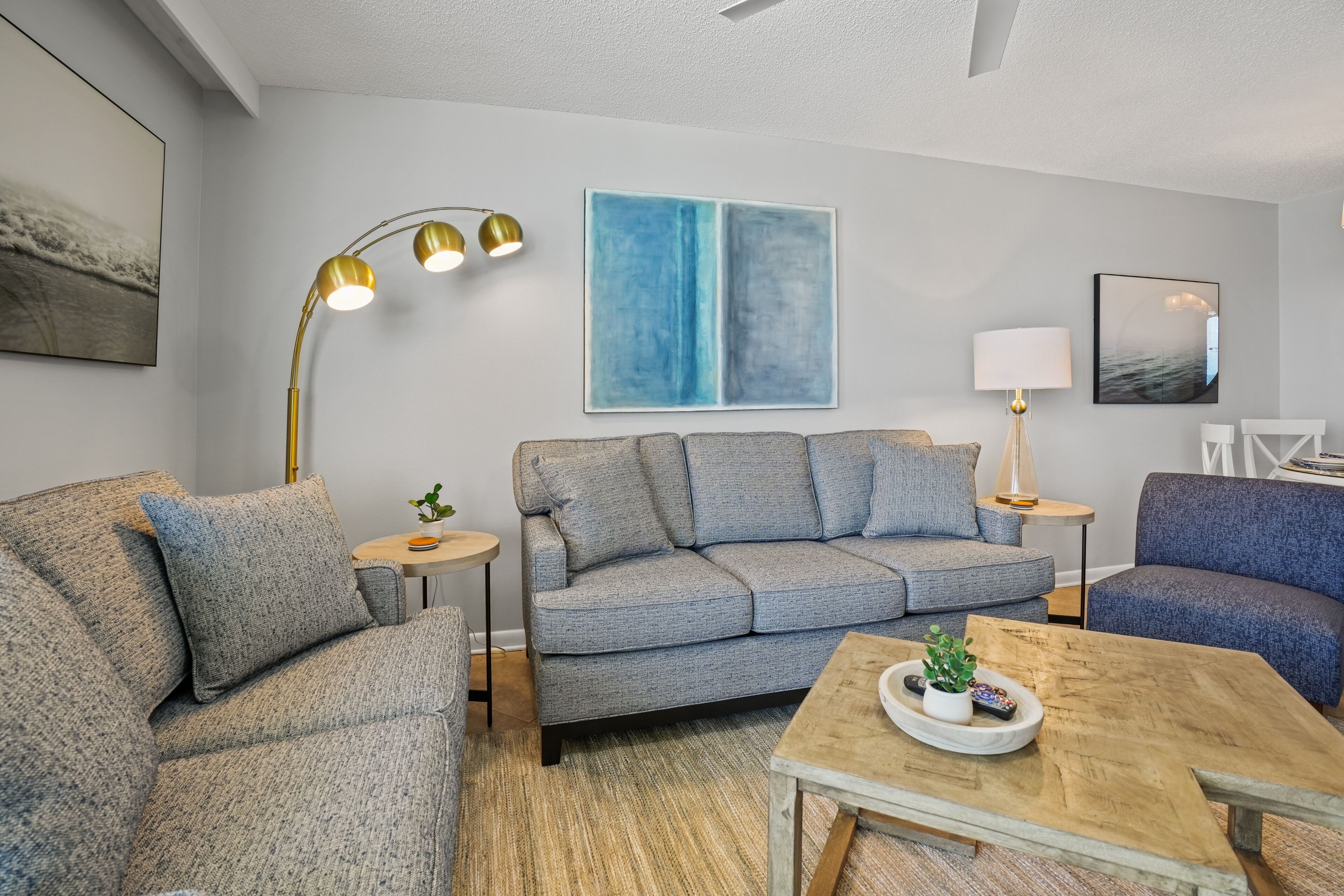 A modern living room with a grey sofa, a wooden coffee table, and a floor lamp.