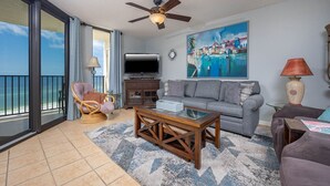 A living room with a sofa, armchair, coffee table, and a television. - Phoenix Iv 4085 3 Bedroom Condo (Orange Beach)