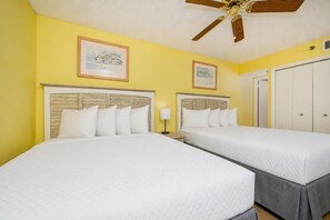 A hotel room with two beds, a ceiling fan, and two framed pictures on the wall. - Phoenix Iii 3098 2 Bedroom Condo (Orange Beach)