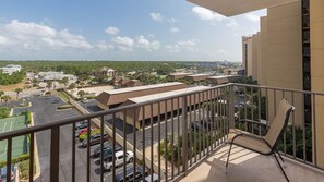 A balcony with a view of a parking lot and buildings. - Phoenix Iv 4075 3 Bedroom Condo (Orange Beach)