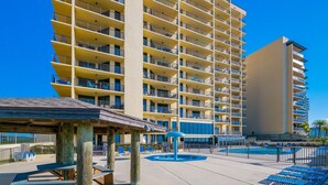 A multi-story hotel with balconies, a pool area, and a covered seating area. - Phoenix Iv 4075 3 Bedroom Condo (Orange Beach)