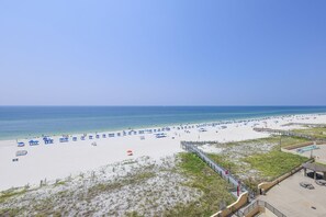 A beach with a boardwalk, umbrellas, and lounge chairs. - Phoenix Iii 3068 2 Bedroom Condo (Orange Beach)