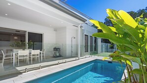 Ein moderner Pool mit klarem, blauem Wasser, umgeben von einer Glasumrandung.