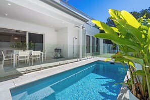 A modern swimming pool with clear blue water, surrounded by a glass fence. - 17 Elluisa Close : 4  BR, 3  BA House in Forster, Sleeps 8 (Forster)