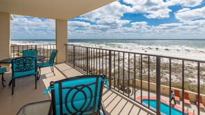 Ein Balkon mit Blick auf den Strand, einen Pool und Sitzgelegenheiten im Freien.