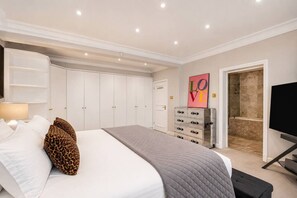A bedroom with a bed, wardrobe, dresser, and a TV. - Luxury Holland Park 3-bed With Private Balcony (London)