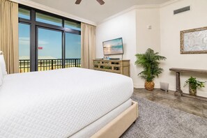Ein Hotelzimmer mit einem großen Bett, einem Fernseher, Blick ins Freie und einer dekorativen Wandgestalt.