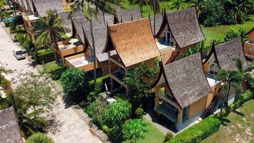 A resort with multiple bungalow-style buildings, each with a sloped roof and surrounded by lush greenery.
