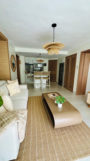 A modern living room with a sofa, a coffee table, and a hanging light fixture. -  XANADU CASA DE LA PLAYA (Puerto Plata)
