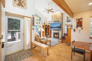 Ein gemütliches Wohnzimmer mit Kamin, Holzmöbeln und einem Fernseher.