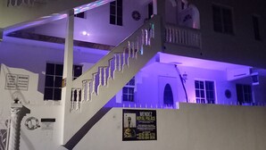 A multi-level building with a staircase, balconies, and a sign for Mendez Royal Palace. - COLDEST 1-bedroom apartment with AC in serene Montego Bay (Montego Bay)