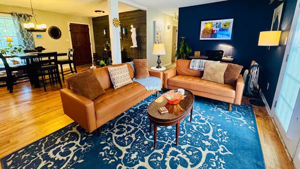Ein Wohnzimmer mit zwei Sofas, einem Couchtisch und einem Teppich mit Muster.