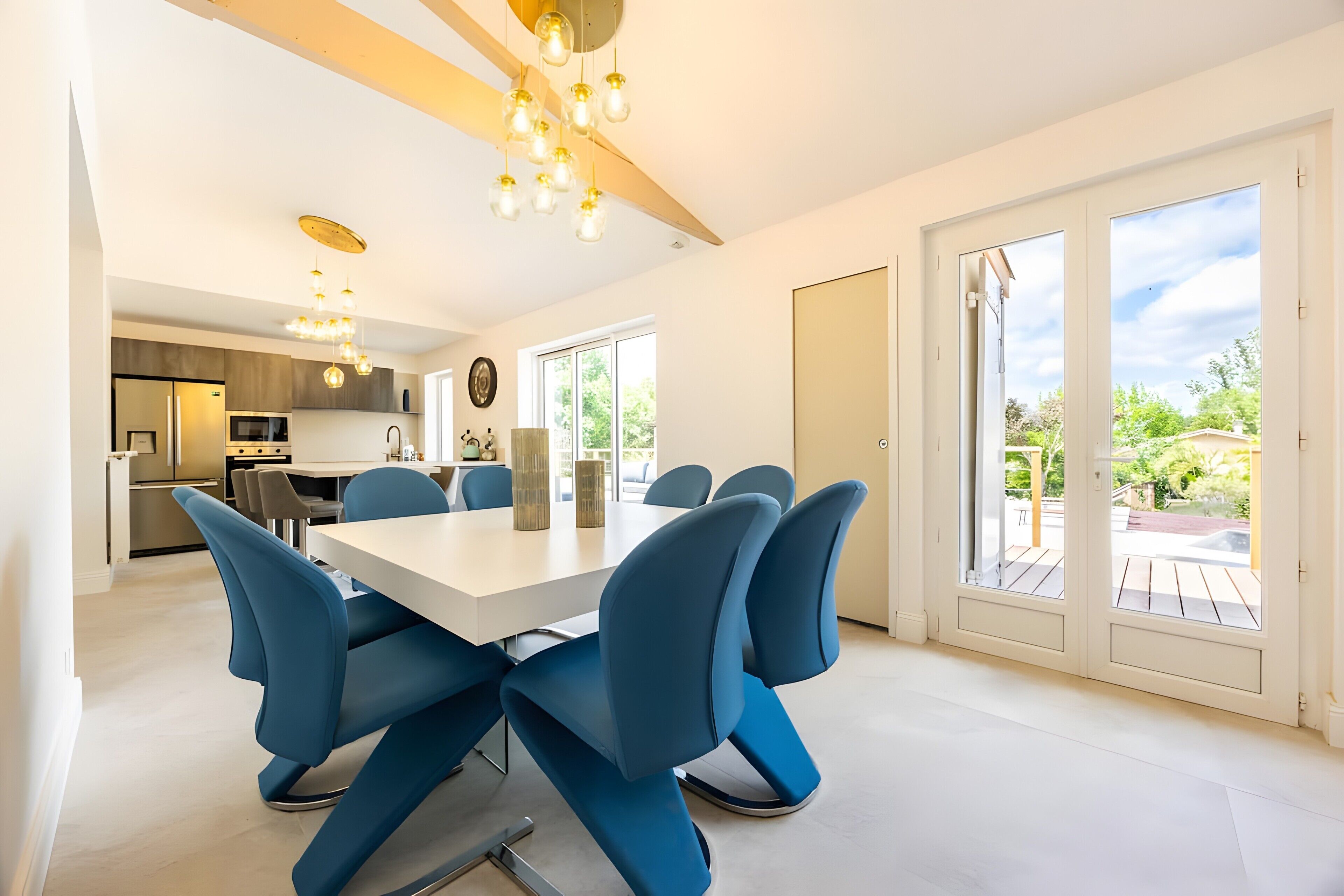 Una cocina moderna con comedor, ventanas amplias y vistas al exterior.