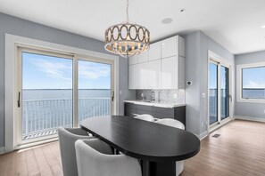 Eine moderne Küche mit Essbereich, großen Fenstern und Blick auf das Wasser.