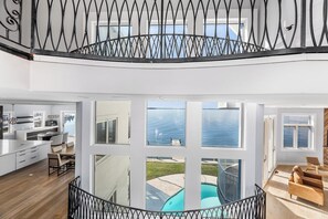 Un interior amplio con cocina, comedor y vista a una piscina.