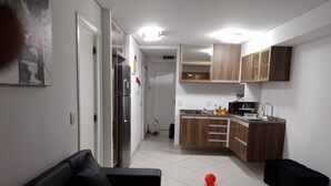 A modern kitchen with wooden cabinets, a refrigerator, and a sink. - Landscape Apartment in Fortaleza Gold (Fortaleza)