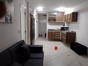 A modern kitchen with wooden cabinets, a refrigerator, and a sink. - Landscape Apartment in Fortaleza Gold (Fortaleza)