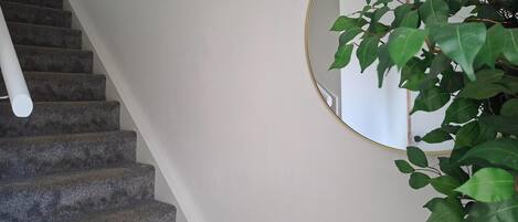 A staircase with carpeted steps and a white wall.