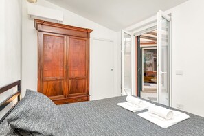 A bedroom with a bed, a wardrobe, and a sliding glass door leading to a balcony. - [IndependentHouse] 5TERRE/ garden+parking+ A/C (La Spezia)