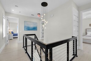 A modern interior with a staircase, a painting, and a ceiling light fixture. - Brand new, walking distance to Sombrero Beach! 4 Bed/4.5 Bath outdoor kitchen. (Marathon)