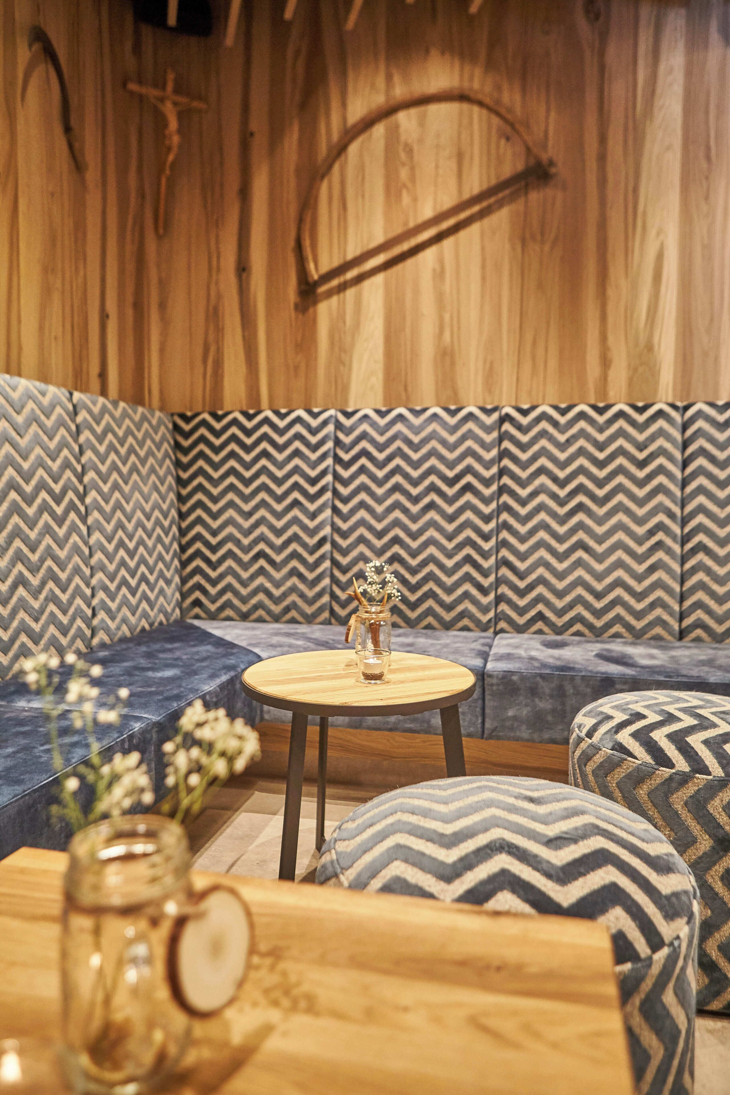 Un rincón acogedor con cojines estampados y una mesa redonda de madera con un adorno decorativo.
