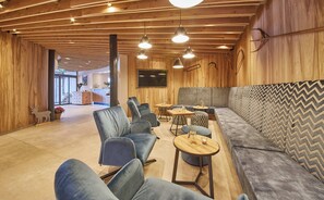 A modern interior with a wooden ceiling, seating area, and a television.
