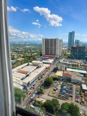 A cityscape with high-rise buildings, a parking lot, and a clear sky. - The Executive Rentals-Makati Skyview Condo| Near Airport| Walk to Malls & MRT (Makati City)