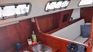 A compact kitchenette with a gas stove, sink, and control panel.
