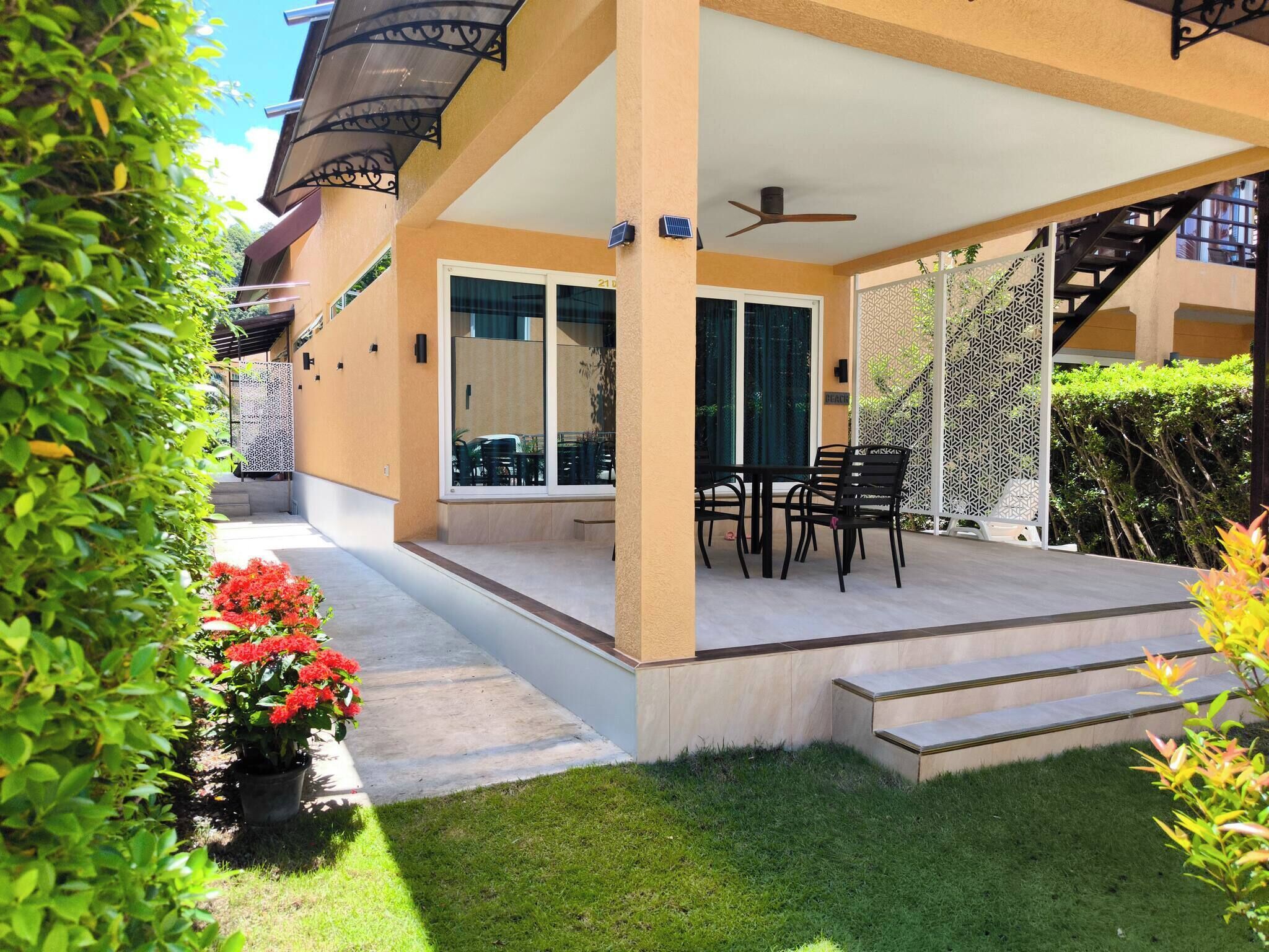 A covered outdoor patio with a table and chairs, a ceiling fan, and a view of the street.