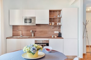 A modern kitchen with white cabinets, a stainless steel oven, and a wooden backsplash. - [Portoseaview] Terrace+A/C (Portovenere)