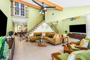 A spacious living area with a large sectional sofa, a dining table, and a staircase leading to an upper level. - 25% Off Oct 22-25 Perfect 4 Families Pool, Tennis! (Palm Springs)